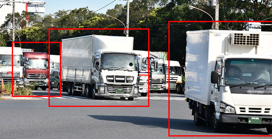 乗用車やトラックなど色々な種類の車が並ぶ画像